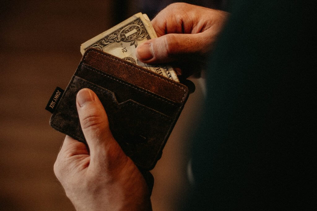 person pulling money out of wallet
